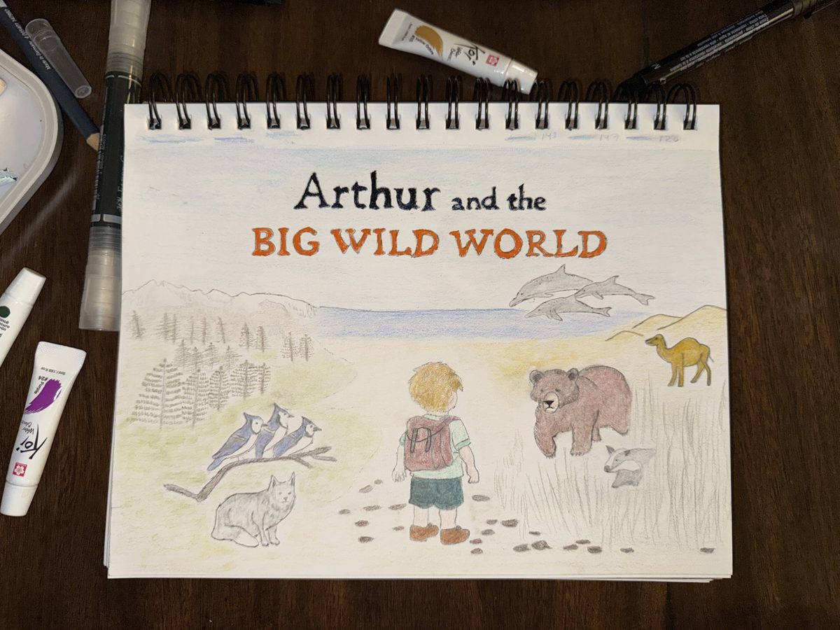 The finished watercolor cover in the same sketchbook, with paint tubes and brushes on the table.